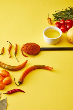 Chili peppers with vegetables and olive oil on yellow background clipart