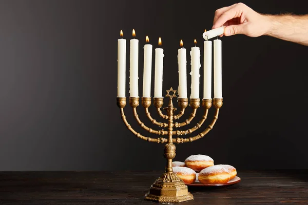 Vista Ritagliata Dell Uomo Accendere Candele Menorah Vicino Ciambelle Sfondo — Foto Stock