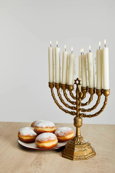 Deliziose Ciambelle Vicino Candele Ardenti Menorah Hanukkah Isolato Bianco — Foto Stock