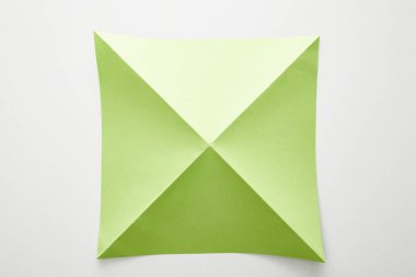Beyaz arkaplan üzerindeki boş yeşil origami kağıdının üst görünümü