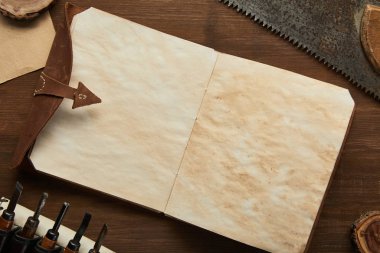 Eski marangozluk araçlarının en üst görünümü ahşap masadaki boş klasik not defterinin yanında