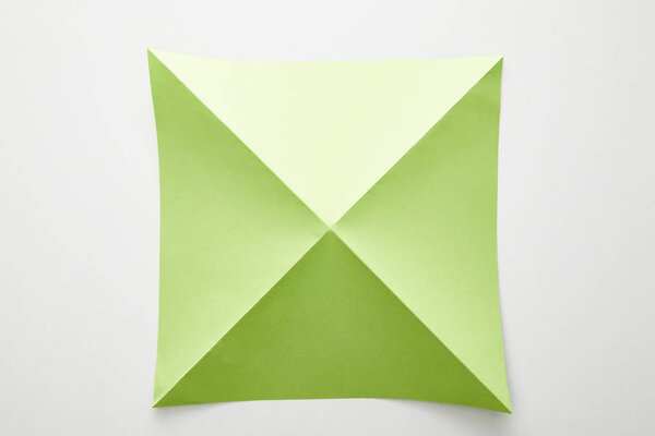 top view of empty green origami paper on white background