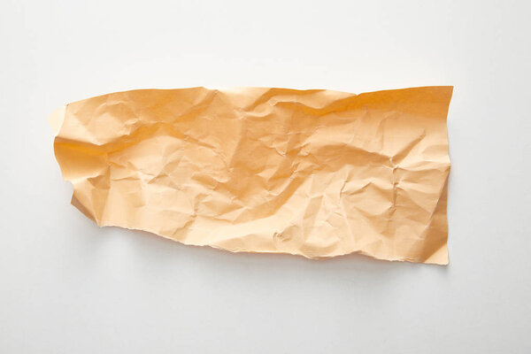 top view of empty orange crumpled paper on white background