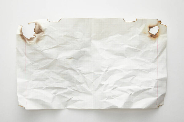 top view of empty crumpled and burnt vintage paper on white background