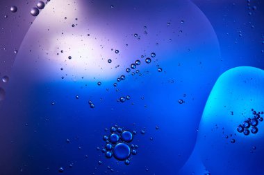 Beautiful abstract background from mixed water and oil in blue and purple color clipart