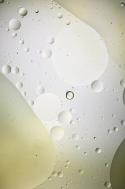 Açık yeşil ve gri renkli, karışık su ve yağ kabarcıklarının soyut dokusu