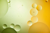 kreatív elvont háttér vegyes víz és olaj zöld és narancs színű