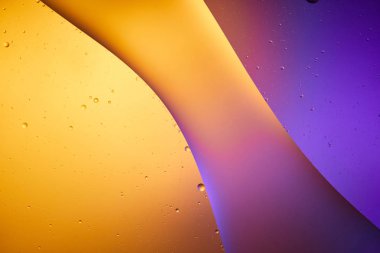 Beautiful abstract background from mixed water and oil in orange and purple color clipart