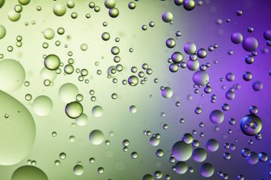 abstract purple and green color background from mixed water and oil bubbles clipart