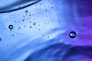 Beautiful abstract background from mixed water and oil in blue and purple color clipart