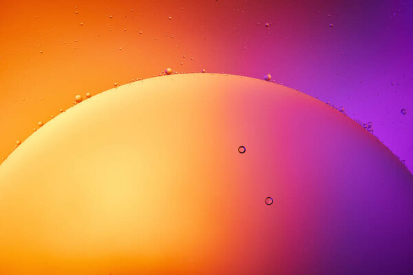 Beautiful abstract background from mixed water and oil in orange, red and purple color