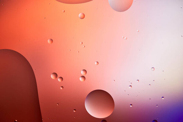 Красивый абстрактный фон из смешанной воды и масляных пузырей красного и фиолетового цвета
