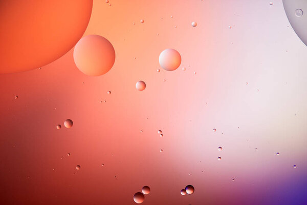 creative background from mixed water and oil bubbles in red and purple color