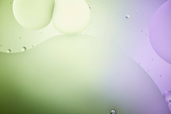 Красивый абстрактный фон из смешанной воды и масла в светло-зеленый и фиолетовый цвет
