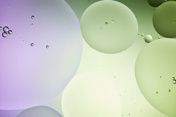 творческий абстрактный фон из смешанной воды и масла в светло-зеленый и фиолетовый цвет
