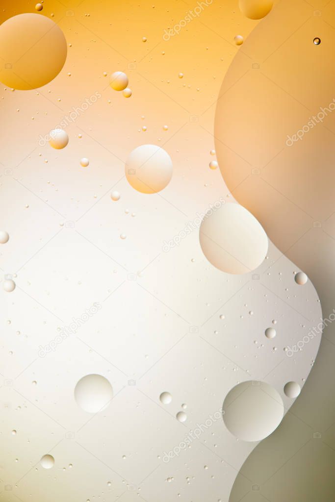 Beautiful abstract background from mixed water and oil in light orange and grey color