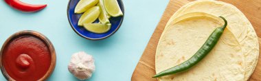 Tortilla manzarası, sarımsaklı domates sosu ve mavi arka planda limon dilimleri, panoramik çekim
