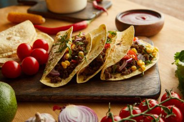 Tahta masada kıymalı ve sebzeli taze taco.
