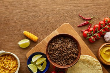 Tahta arka planda taco malzemeleri olan tortilla manzarası