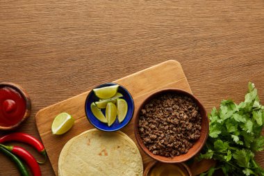 Tahta arkaplanda taco malzemelerinin en üst görünümü