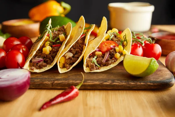 Selektiv Fokus Färska Tacos Med Ingredienser Träbord Svart Bakgrund — Stockfoto