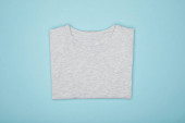 top view of blank basic grey t-shirt isolated on blue
