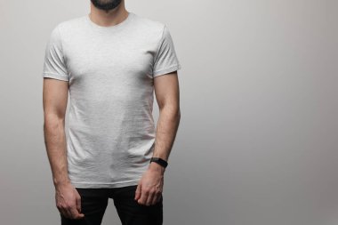 Boş gri tişörtlü sakallı adamın gri arka planda izole edilmiş görüntüsü.