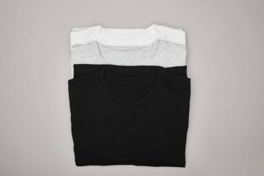 top view of blank basic black, white and grey t-shirts isolated on grey clipart