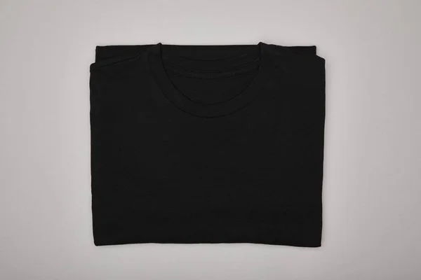 灰色隔离开的空白基本黑色T恤的顶部视图 — 图库照片