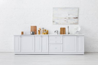 Minimalist beyaz mutfak iç dekorasyonu mutfak eşyaları ve tuğla duvar resimleri.
