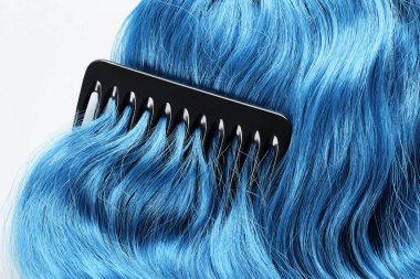 Top view of comb on colored blue hair isolated on white clipart