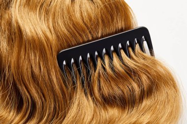 Kahverengi saçın beyaz üzerine izole edilmiş tarağın üst görüntüsü