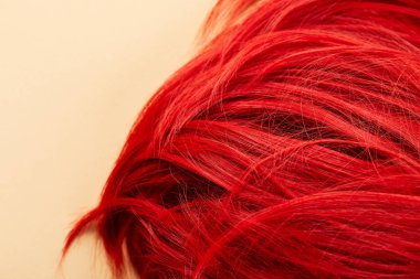 Top view of red colored hair on beige background clipart