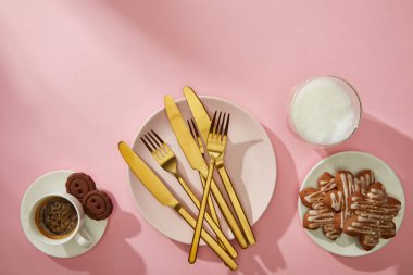 Pembe arka planda sütlü ve kahveli lezzetli kurabiyelerin üst görüntüsü