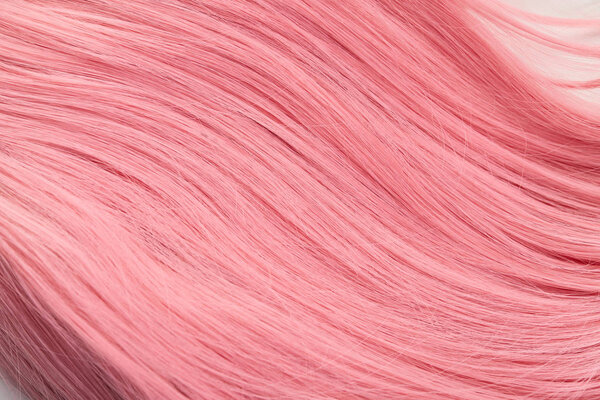 Close up view of pink hair on white background