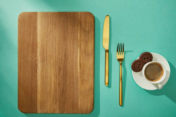 Top View Wooden Cutting Board Cutlery Coffee Cookies Turquoise Surface — Stock Photo, Image