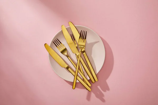 Top View Shiny Golden Cutlery Empty Plate Pink Background — Stock Photo, Image