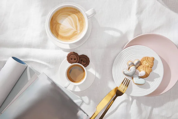 Top View Gourmet Cookies Cups Coffee Magazines White Tablecloth — 스톡 사진