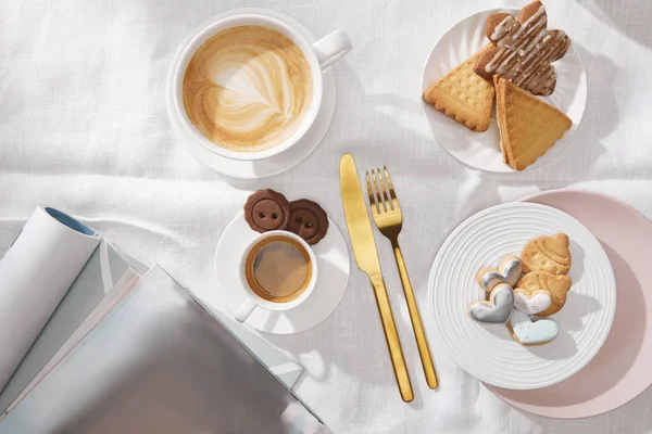 白い布にコーヒーや雑誌と焼きたてのクッキーのトップビュー — ストック写真