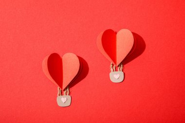 top view of paper heart shaped air balloons with locks on red background clipart