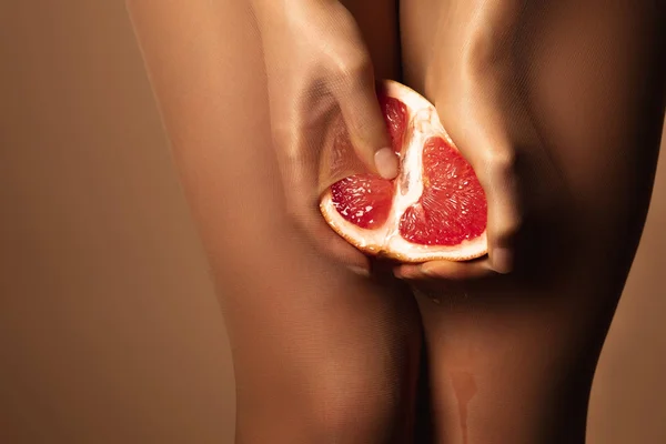 Vedere Decupată Femeii Pantaloni Nailon Stoarce Grapefruit Jumătate Izolat Maro — Fotografie, imagine de stoc