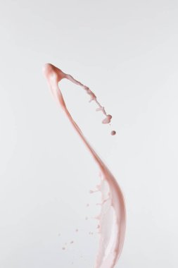 Beyaz üzerine damlalar bırakılmış taze pembe süt sıçraması.