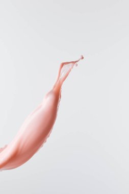 Beyaz üzerine damlalar bırakılmış taze pembe süt sıçraması.