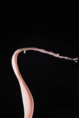 pürüzsüz taze pembe süt damlaları siyah üzerine izole edilmiş