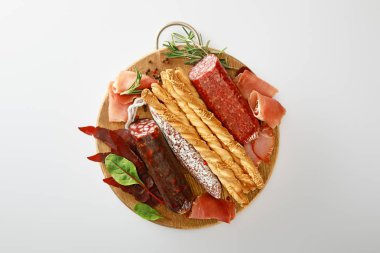Ekmek ve otlarla servis edilen lezzetli et tabağının üst görüntüsü beyaz üzerinde izole edilmiş.