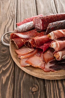 top view of delicious meat platter served with breadsticks on wooden board clipart