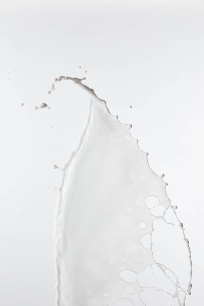 брызги чистого белого молока с капельками, выделенными на белом
