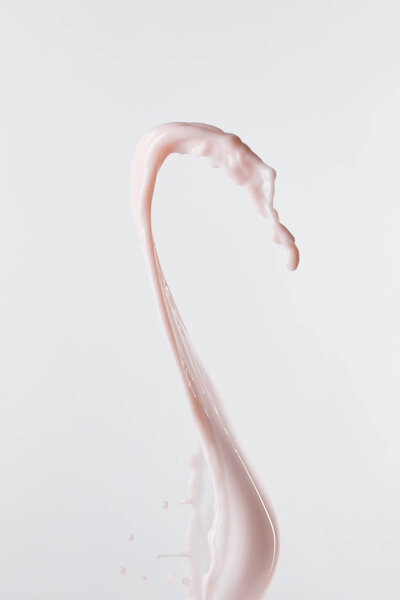 брызги свежего розового молока с каплями, изолированными на белом
