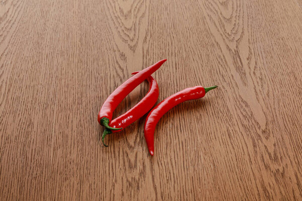 red spicy chili peppers on wooden brown table
