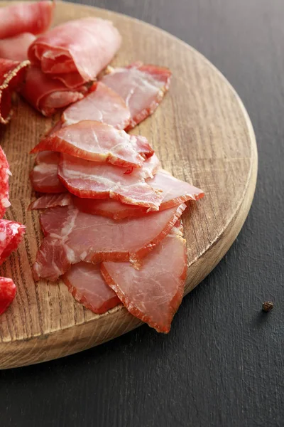 Prato Carne Deliciosa Com Presunto Placa Madeira Superfície Preta — Fotografia de Stock